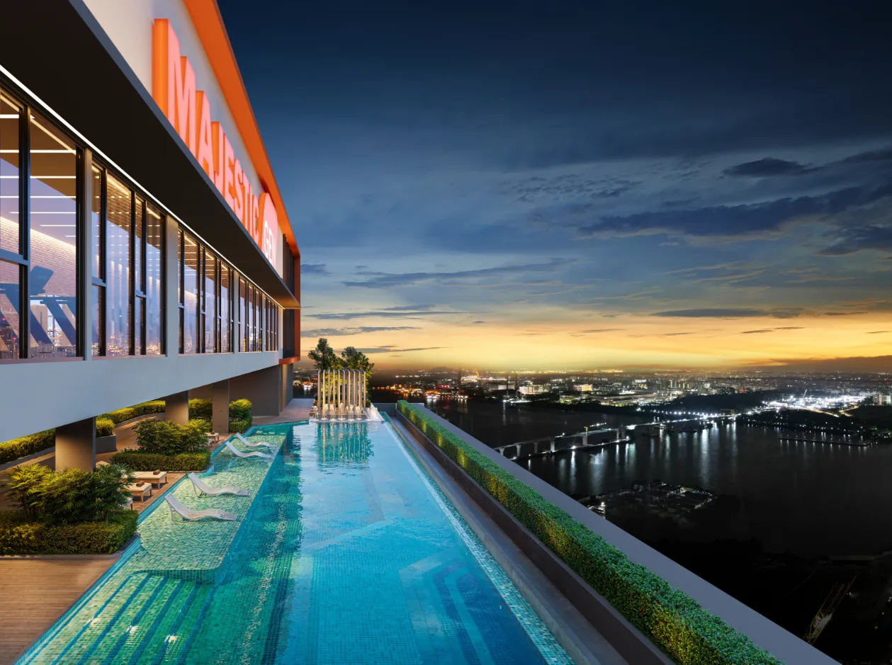 Rooftop infinity pool at Gen Rise at dusk, overlooking the Johor Straits and the lights of the causeway to Singapore
